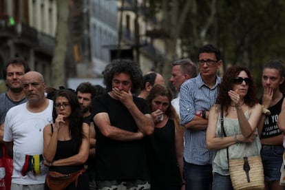 Un grupo de gente muestran su apoyo frente a un memorial por las víctimas en Las Ramblas.