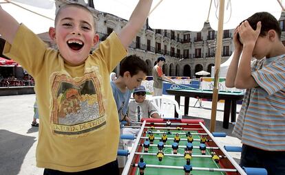 Varios niños juegan al futbolín en la plaza Nueva de Vitoria, durante la campaña "Juegos en la calle".