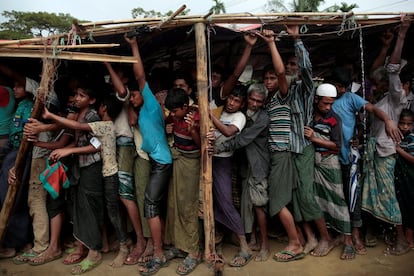 Refugiados rohingya esperan a recibir protección para la lluvia en el campamento de refugiados de Cox's Bazar en Bangladés.