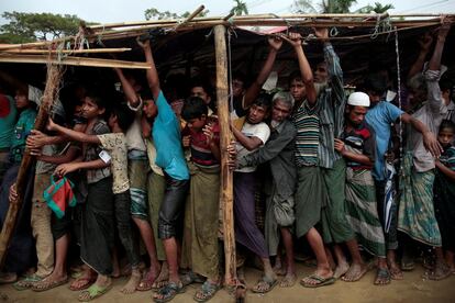 Refugiados rohingya esperan a recibir protección para la lluvia en el campamento de refugiados de Cox's Bazar en Bangladés.