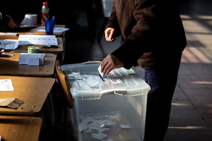 Un hombre introduce su voto en la urna.