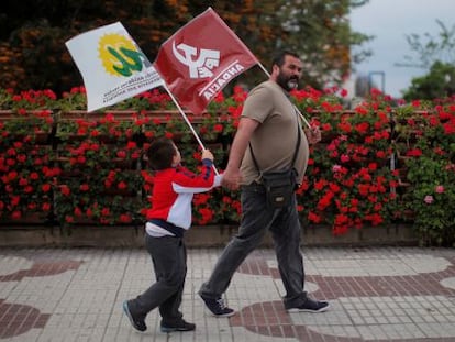 Un simpatizante y su hijo con banderas de IU. 