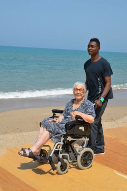Abubakar Yabuku, de Nigeria, pasea en la playa a Anita Pastorella.