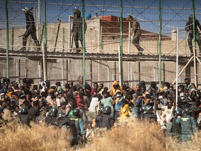 FILE - Riot police officers cordon off the area after migrants arrive on Spanish soil and crossing the fences separating the Spanish enclave of Melilla from Morocco, in Melilla, Spain, June 24, 2022. Spain’s interior minister, Fernando Grande-Marlaska, is coming under increased pressure to be more transparent about how Spanish security forces responded to a June incident at its border with Morocco that led to the deaths of at least 23 migrants in the North African enclave of Melilla. (AP Photo/Javier Bernardo, File)