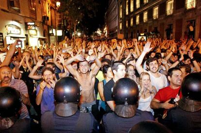 Los indignados cantan sus consignas mientras la policía permanece impasible.