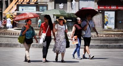 Un grupo de turistas pasea por la Puerta del Sol.
