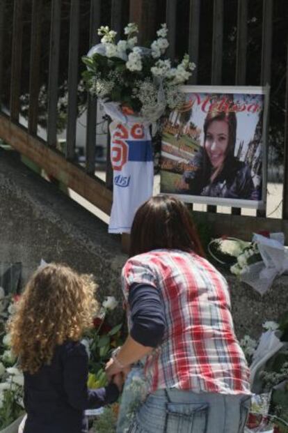 Dos personas colocan flores frente a una foto de la estudiante muerta ayer en Brindisi.