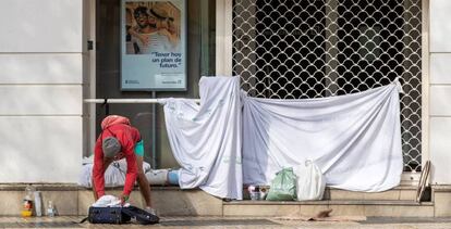 Una persona sin hogar, tras pasar la noche en la puerta de una entidad bancaria. 