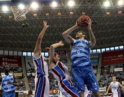 Guille Rubio trata de encestar ante dos jugadores del Blusens Monbus.