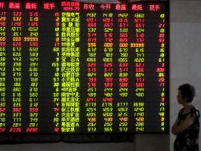 Un inversor observa los precios de la bolsa mostrados por un panel electrónico en un casa de intercambio de valores en el centro de la ciudad de Qindao, al este de la provincia de Shandong, China. EFE/Archivo