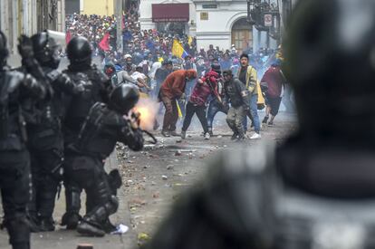 Los manifestantes se enfrentan con la policía antidisturbios mientras miles de personas marchan contra la decisión del presidente ecuatoriano, Lenin Moreno, de recortar los subsidios al combustible, en Quito. 