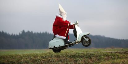 Un hombre vestido de Santa Claus a bordo de una 'scooter' de camino a una fiesta navideña cerca de Laubbach (Alemania).