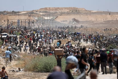 Ciudadanos palestinos transportan ayuda recibida de la Fundación Humanitaria de Gaza, respaldada por EE UU, en Al Bureij, en el centro de la Franja. 