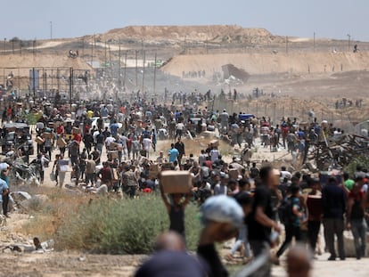 Ciudadanos palestinos transportan ayuda recibida de la Fundación Humanitaria de Gaza, respaldada por EE UU, en Al Bureij, en el centro de la Franja.