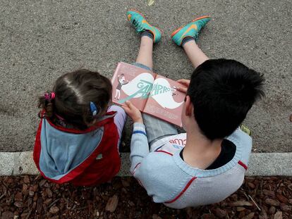 Ni&ntilde;os leyendo en la Feria del Libro de Madrid, en el parque del Retiro.