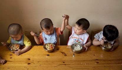 Un grupo de niños come en un orfanato en Pekín.