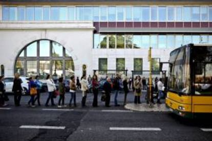 Varios usuarios de transporte público esperan en una parada de autobús delante de la estación de metro Cais do Sodre durante una huelga de 24 horas de los trabajadores de metro en contra de los recortes previstos para el sector en los Presupuestos Generales del Estado de 2014 en Lisboa (Portugal).