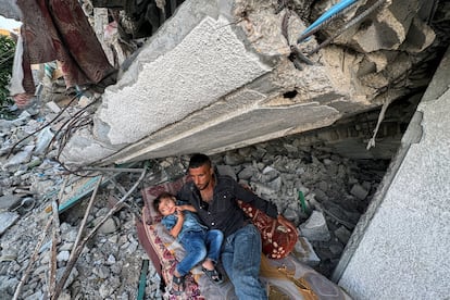 Padre e hijo duermen entre los escombros de su casa destruida en Jan Yunis, el 26 de septiembre de 2024.