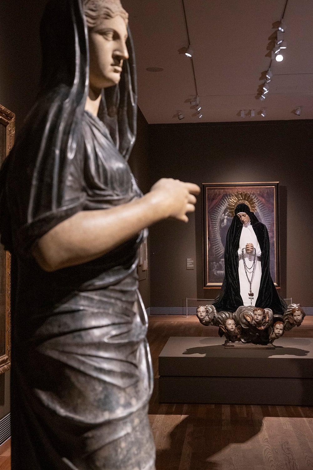 La Virgen de la Soledad de Luis Salvador Carmona (en segundo término) expuesta en la muestra 'Darse la mano' del Museo del Prado.