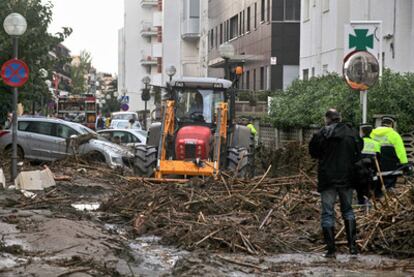 El personal de limpieza retira los escombros que el temporal ha arrastrado por las calles de Salou.