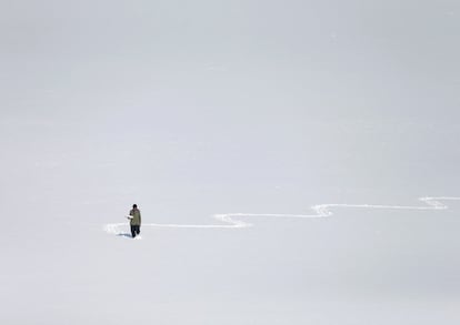 Un hombre camina sobre el lago Qargha, junto a Kabul (Afganistán), cubierto de nieve.