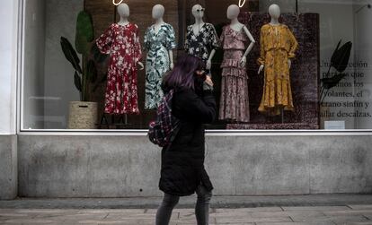 Una mujer pasa por delante de una tienda cerrada en la Gran Vía de Madrid.