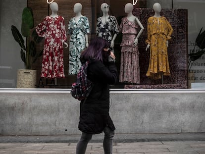 Una mujer pasa por delante de una tienda cerrada en la Gran Vía de Madrid.