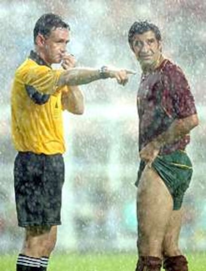 Figo sigue, bajo la lluvia, las indicaciones del árbitro, el escocés Hugh Dallas.