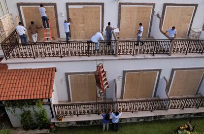 Trabajadores colocan tablones de madera para proteger los ventanales de un hotel en Playa del Carmen, México, este miércoles, antes de la llegada del huracán.