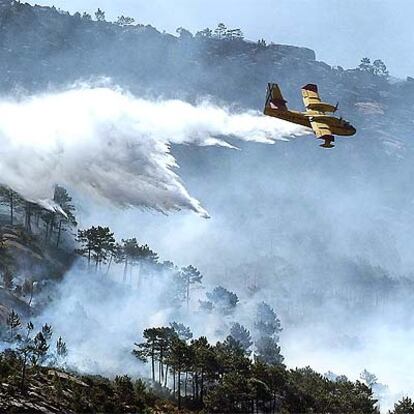 Un avión descarga agua sobre el monte O Pindo, en Carnota (A Coruña).