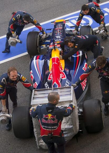 El piloto alemán de Red Bull, Sebastian Vettel, es ayudado por sus mecánicos durante la segunda jornada de entrenamientos.