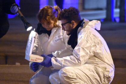 Dos miembros de la policía forense recogen evidencias de la zona del tiroteo entre la policía y Anis Amri, en Milán.