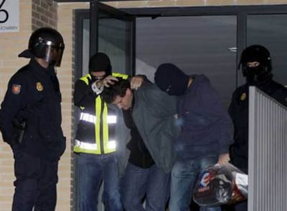 Agentes del Cuerpo Nacional de Policía trasladan a uno de los detenidos en Pamplona.