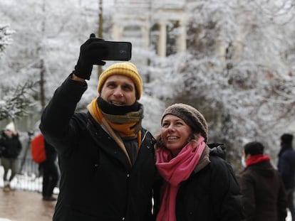 Dos personas se toman una foto en el Retiro, en Madrid, durante la nevada.