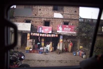 "Rojo saturado, exaltación de una imagen inexistente, a la que se desea aspirar". Dos mujeres en la puerta de un comercio junto a unos llamativos carteles publicitarios.