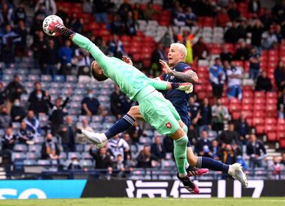 El portero checo, Tomas Vaclik, trata de despejar un balón ante la presión del jugador de Escocia Lyndon Dykes durante el partido de la UEFA EURO 2020 que ha enfrentado a Escocia y a la República Checa en Glasgow, Escocia.