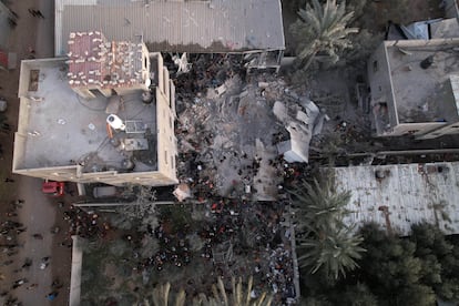 Vista aérea de un edificio residencial destruido, a causa de un ataque israelí, donde decenas de personas buscan víctimas entre los escombros, este viernes en Deir al Balah.