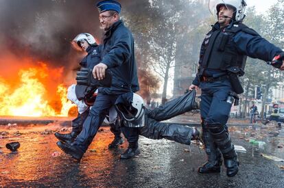 La policía se lleva a un manifestante tras los violentos enfrentamientos durante la protesta, en Bruselas, contra los presupuestos que prevé el Gobieno belga.