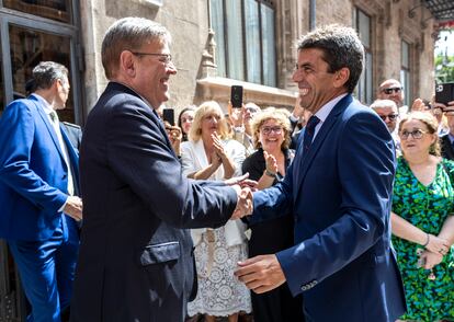 El presidente saliente, el socialista Ximo Puig, saluda al nuevo presidente, Carlos Mazón, a las puertas del Palau de la Generalitat, este lunes  