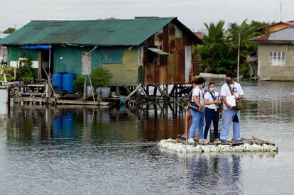 Trabajadores sanitarios se trasladan en una balsa improvisada durante la vacunación casa por casa contra la covid-19 en la ciudad de Valenzuela (Filipinas).