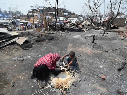 Una madre y su hijo intentaban rescatar arroz tras el incendio, el pasado jueves en el campo de refugiados de Kutupalong (Bangladés).