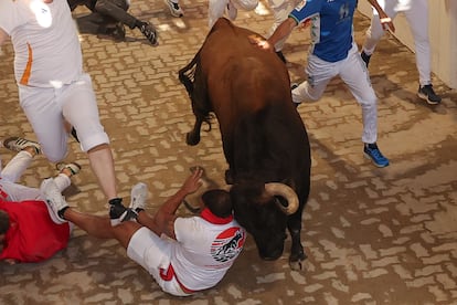 Un corredor es embestido por uno de los toros de los astados de la ganadería Álvaro Núñez en la entrada del callejón de la plaza de toros de Pamplona.