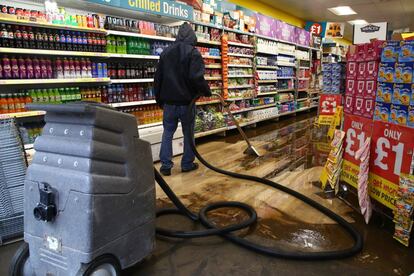 Un hombre limpia un supermercado en Pontypridd, en el sur de Gales. El local se ha visto afectado por las inundaciones causadas por la tormenta.