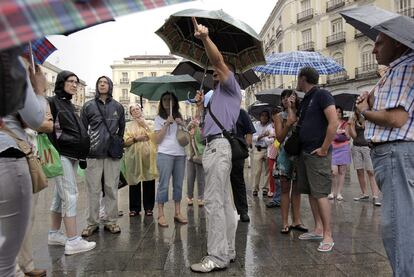 La lluvia irrumpió ayer por la tarde en el verano madrileño con algo más de intensidad de lo esperado. Unas densas nubes grises dieron paso a un chaparrón cerrado que pilló de improviso a viandantes y turistas como los de la imagen.