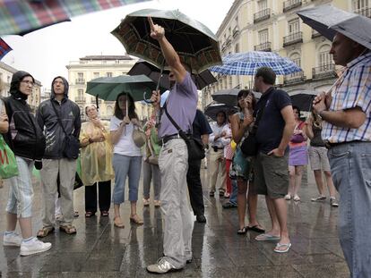 La lluvia irrumpió ayer por la tarde en el verano madrileño con algo más de intensidad de lo esperado. Unas densas nubes grises dieron paso a un chaparrón cerrado que pilló de improviso a viandantes y turistas como los de la imagen.