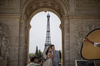 Una pareja china permanece frente a una réplica de la Torre Eiffel, en el World Park de Pekín, para sus fotos de preboda, el 18 de abril de 2019.