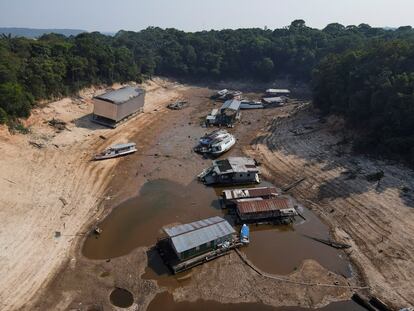 Botes y viviendas varados por el bajo nivel del agua en el río Negro, en Manaos.