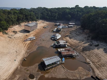 Botes y viviendas varados por el bajo nivel del agua en el río Negro, en Manaos.