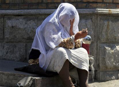 Una mujer uigur mendiga a la entrada de la mezquita Dong Kuruk en Urumqi.