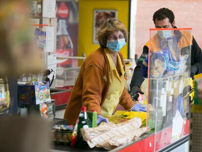 Una cajera trabaja en un supermercado en Manzanares el Real.